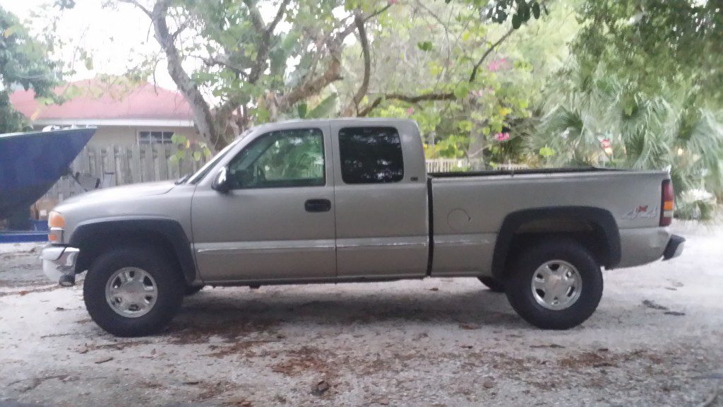 Linc Thomas's tan 1999 GMC 1500 extended-cab pickup with black fender flares, parked outdoors after the Passlock fix