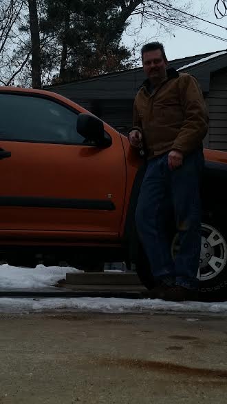 Ryan Cogle standing next to his orange 2007 Chevrolet Colorado after the NEWROCKIES PRO Module fixed his no-start problem