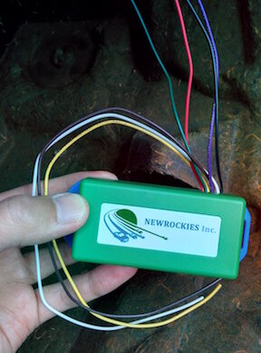A hand holding the wired green NEWROCKIES module in the Monte Carlo