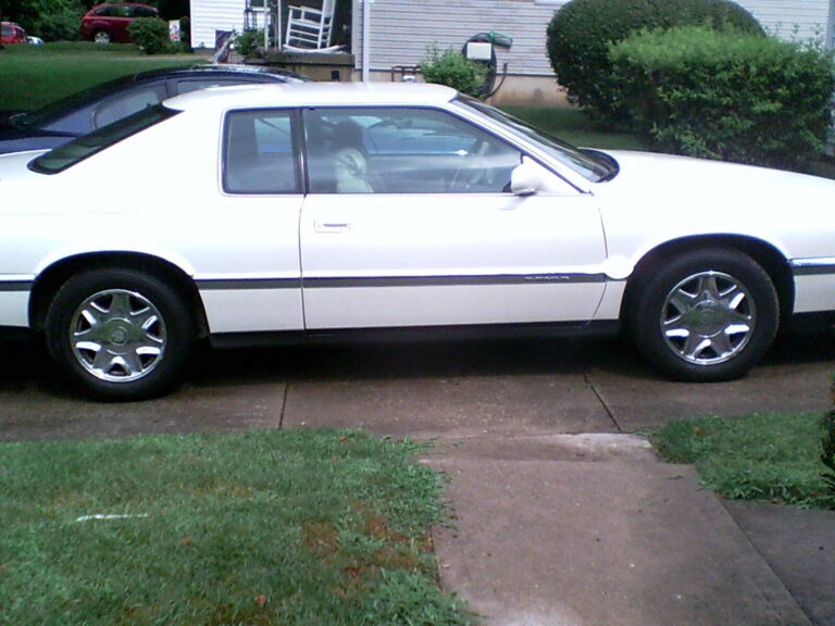 Charles's white 1994 Cadillac DeVille parked on the driveway, running again