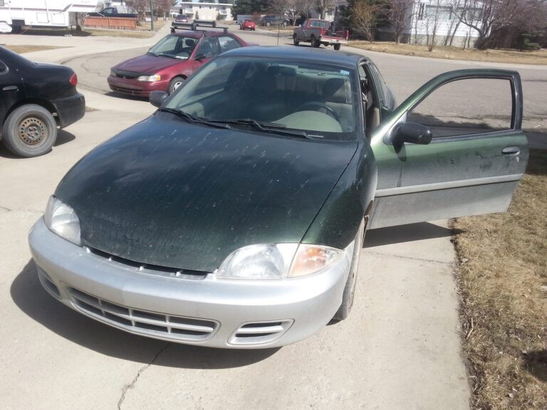 The dark green 2000 Chevrolet Cavalier with its driver's door open