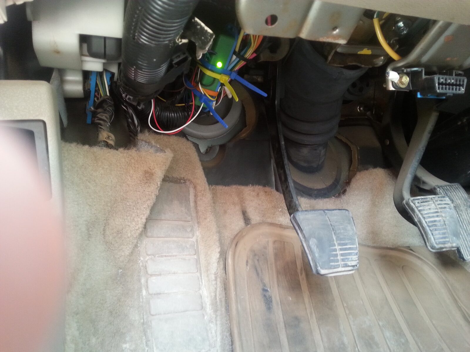 The Cavalier driver footwell with exposed wiring below the dash during the install