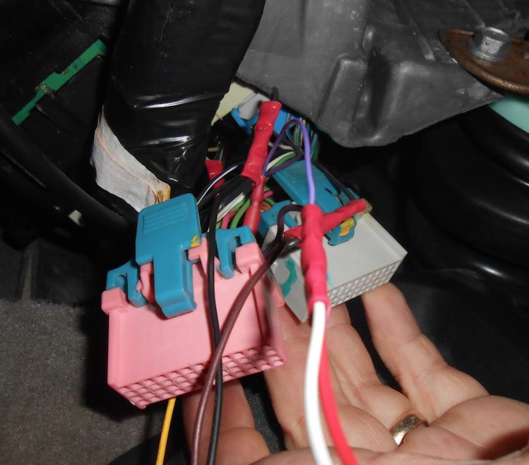 Hand holding the Impala coloured wires and plastic connectors during installation