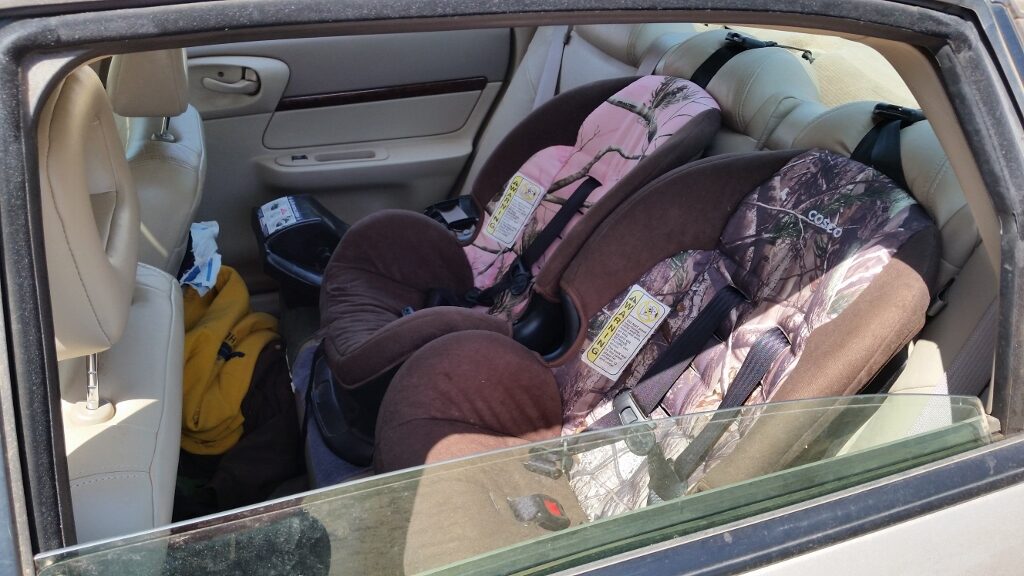 Two camouflage child car seats in the back of the Impala