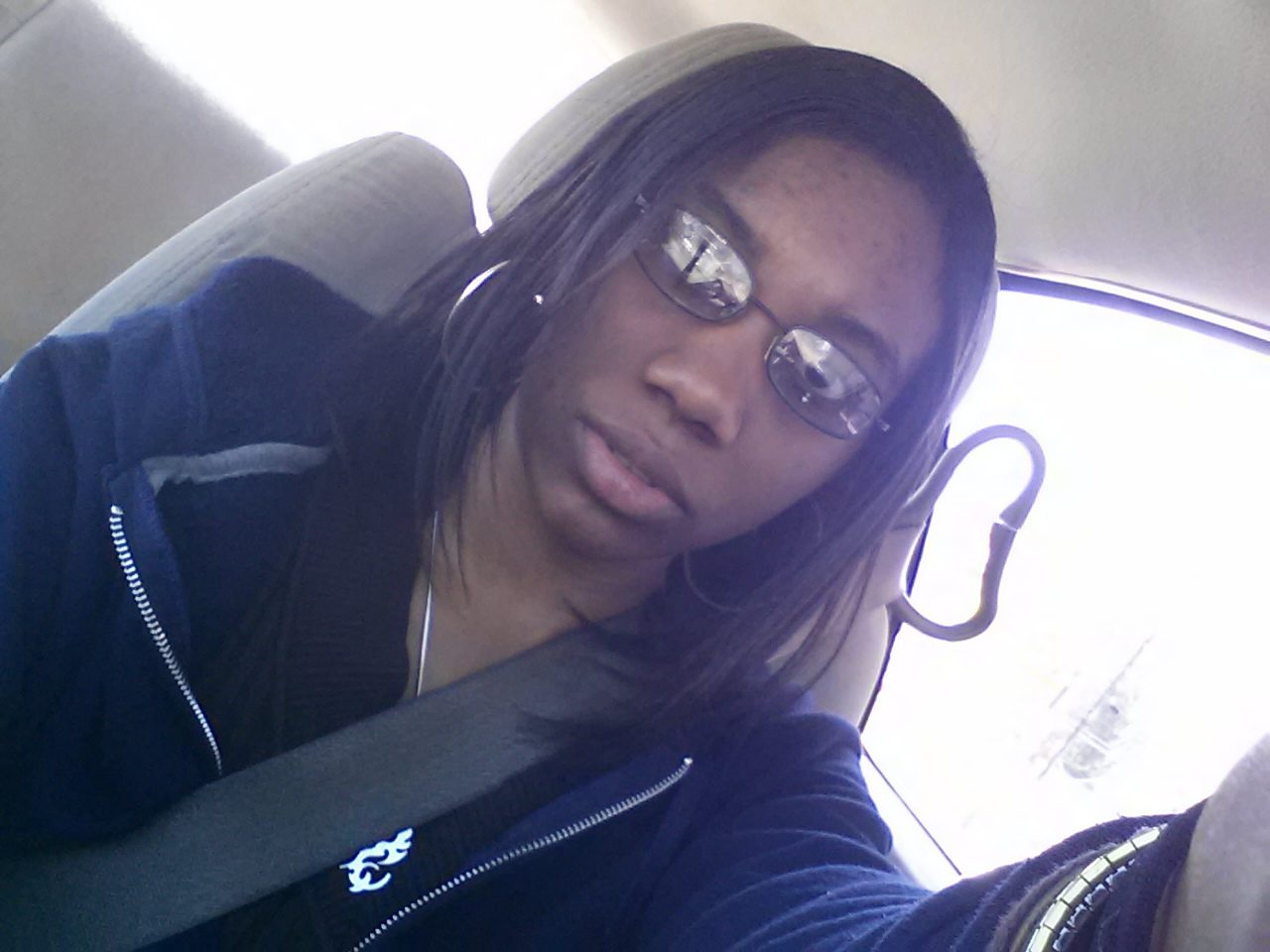 Driver wearing glasses and a seatbelt behind the wheel of the Oldsmobile Alero