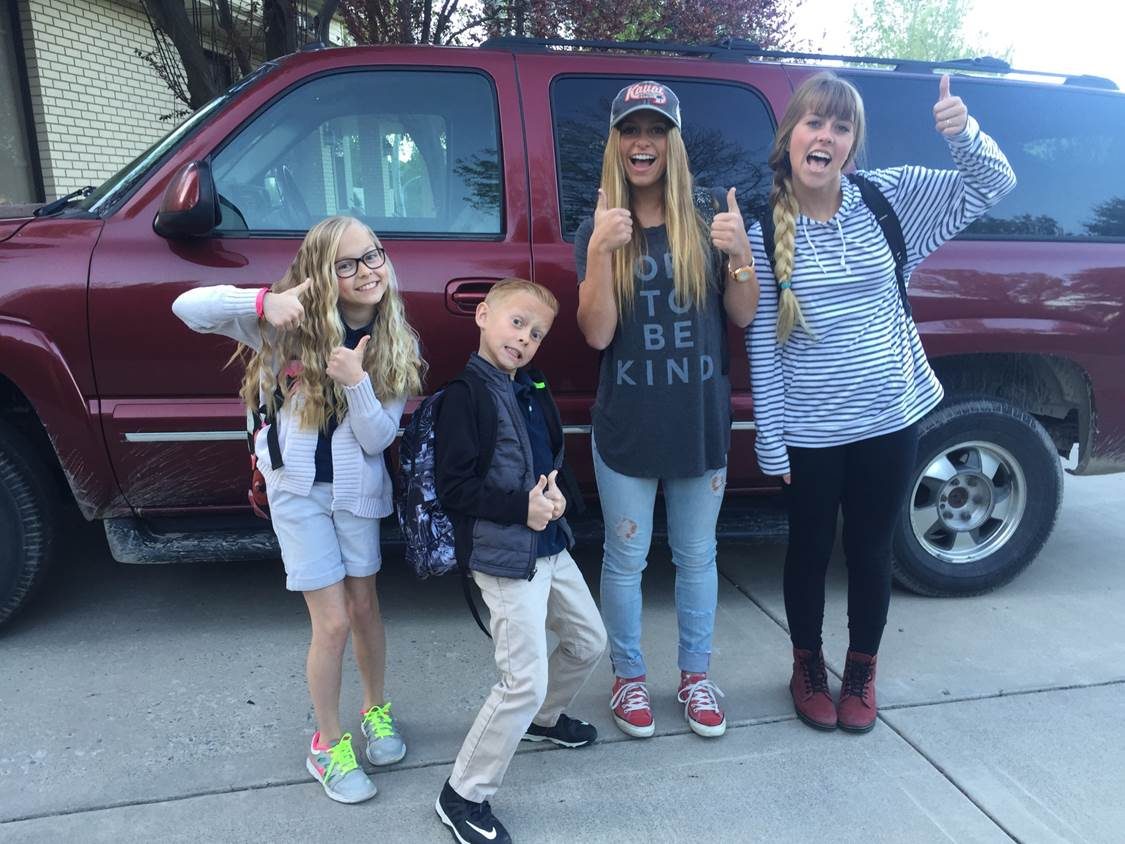 Family posing in front of the red Suburban once ignition was restored