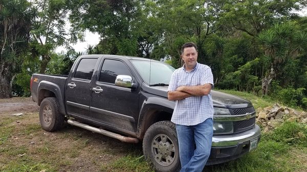 Man standing with crossed arms in front of his 2007 Chevrolet Colorado in Honduras