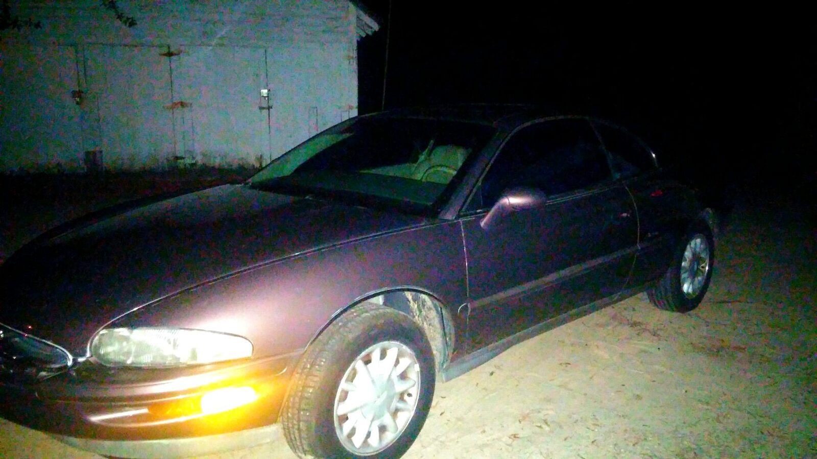 Trent's dark Buick Riviera parked on a dirt surface at night