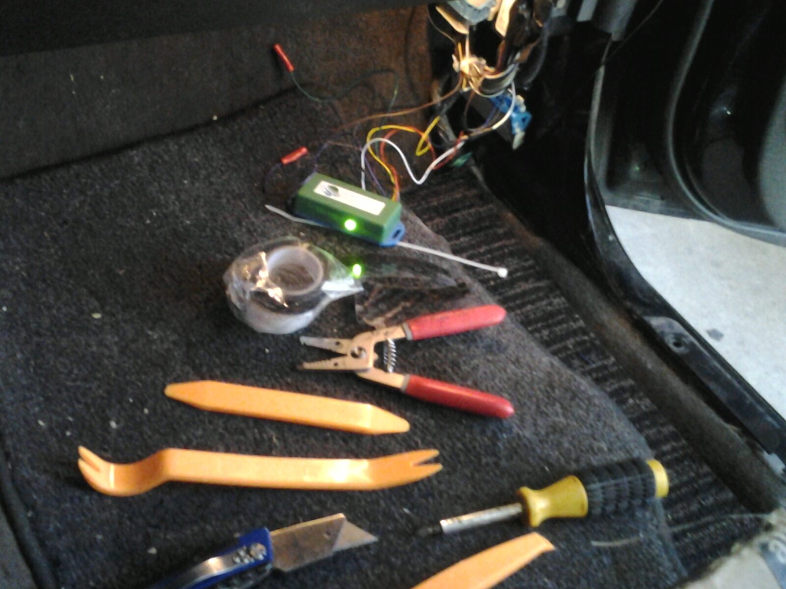 Tools and the wired green module on the Colorado floorboard during the install